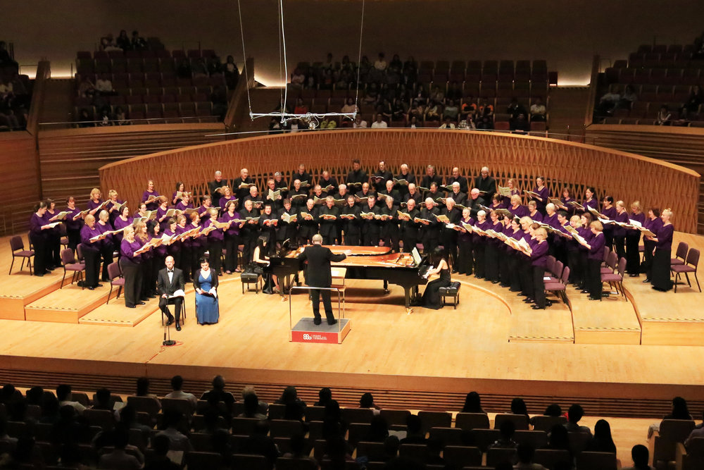 photograph of a large choir performing on a stage