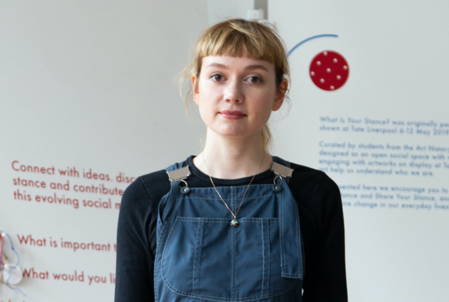 profile image of Fiona Stephens, a woman in her 20's wearing blue denim dungarees.