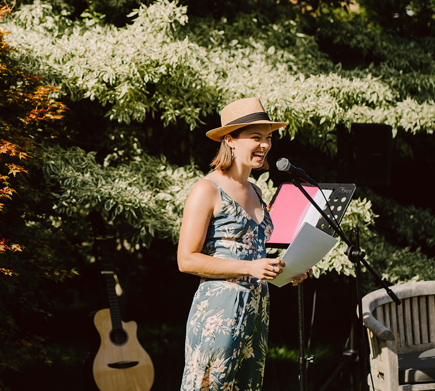 Profile image of Suzy Ward, a white woman delivering an outdoor performance in front of a tree.